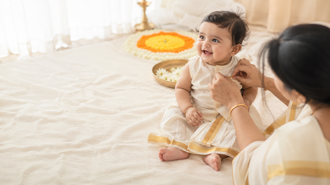 Baby wearing a traditional Onam kasavu outfit.